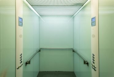 pexels-photo-8243095-8243095 Empty elevator cabin showcasing a clean and minimalist interior with soft lighting.